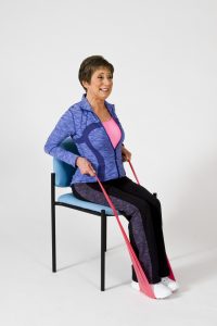 Mary Ann Wilson, RN, shows how strength training can be done in a chair using a resistance band.